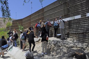 Migrants gather at border wall